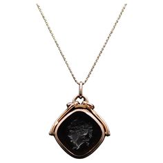 Transport yourself to the captivating era of Victorian Revival with this remarkable mid-century Intaglio locket necklace. This exquisite piece features a 14k gold pendant adorned with an intricate intaglio design, suspended from a 10k gold chain. It encapsulates the charm and elegance of the Victorian era, revitalized for the mid-20th century. The pendant of the necklace is crafted from 14k gold, radiating a warm and luxurious glow. Its surface showcases a meticulously carved intaglio design, a technique that involves incising a pattern or image into the gemstone. This intricate detailing captures the essence of Victorian aesthetics, with motifs such as floral patterns, classical figures, or mythological symbols commonly depicted. The intaglio pendant is designed to hold a cherished keepsa Unique Locket Necklace 1stdibs, Luxury Victorian Style Pendant Locket Necklace, Mythological Symbols, Victorian Aesthetics, 10k Gold Chain, Victorian Revival, Miniature Portraits, Gold Locket, Locket Necklace