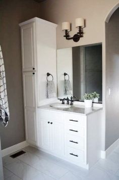 a bathroom with double sinks and two mirrors