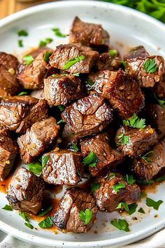 a white plate topped with meat covered in sauce and parsley on top of a wooden table