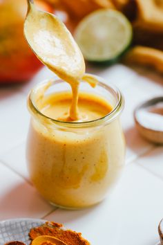 a spoon is being used to dip something into a jar