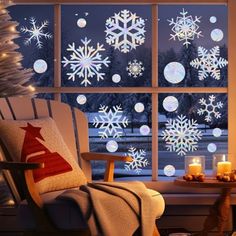 a living room with snowflakes and candles in front of a window that is lit up