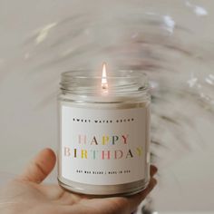 a person holding a birthday candle in their hand