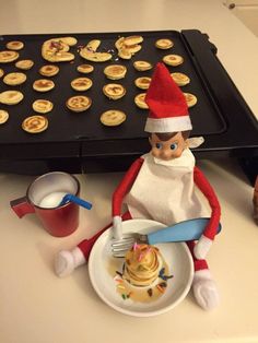 an elf is sitting in front of a plate of food