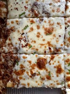 several square pieces of pizza sitting on top of a pan