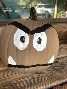 a pumpkin with googly eyes painted on it