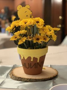 there is a potted plant with yellow flowers in it on a wooden slice that says hunn