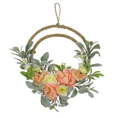 a wreath with flowers and greenery hanging on a rope