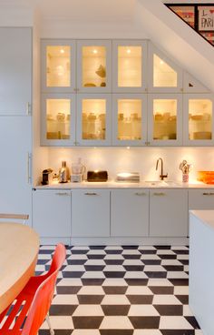 a kitchen with white cabinets and black and white checkered flooring on the walls