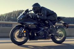 a man riding on the back of a black motorcycle