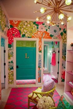 a brightly colored room with pink, green and yellow decor on the walls in front of a turquoise door