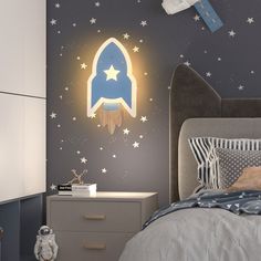 a child's bedroom with a rocket ship wall decal on the wall and stars painted on the walls