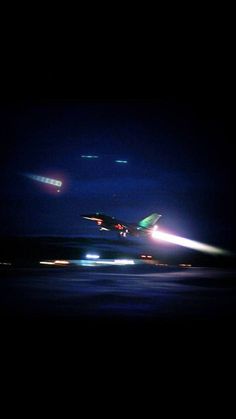 an airplane taking off from the runway at night with bright lights in the dark sky