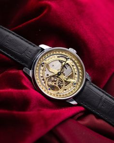 This customized Pobeda watch, with a 37 mm case, boasts a mesmerizing handcrafted skeleton dial that captures the beauty of celestial motifs. The intricate golden patterns etched into the dial evoke images of the cosmos, giving the timepiece an artistic and ethereal quality. The open-worked design of the dial not only enhances its aesthetic appeal but also provides a fascinating view of the inner mechanical workings, making it a true conversation piece. The watch's case is made from polished stainless steel, offering both durability and a sleek, modern look that contrasts beautifully with the ornate dial. This sturdy 37 mm case frames the celestial motif perfectly, ensuring that the dial remains the centerpiece of the design. Paired with a classic black leather strap, the watch exudes soph Luxury Classic Watch With Skeleton Dial, Luxury Automatic Watch Accessories For Gift, Steampunk Silver Watch With Skeleton Dial, Luxury Watches With Subdials For Gift, Luxury Automatic Watch As Gift, Steampunk Automatic Watch For Formal Occasions, Gold Steampunk Watch With Skeleton Dial, Black Watches With Rotating Bezel For Gifts, Antique Skeleton Dial Watch For Formal Occasions