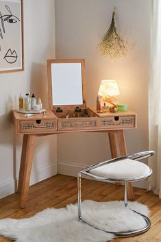 a desk with a mirror, stool and other items on it