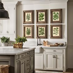 a kitchen with white cabinets and green leaf prints on the wall above the stovetop