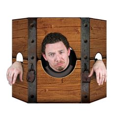 a man is looking through a hole in a wooden box