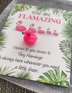 a pink flamingo pin sitting on top of a card