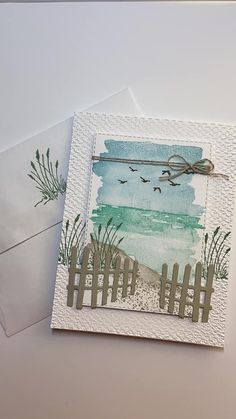 two cards with watercolors on them, one has a fence and the other has seagulls