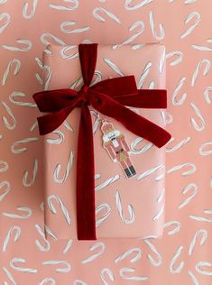 a present wrapped in pink paper with red ribbon