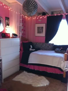 a bedroom decorated in pink, black and white with zebra prints on the bedding