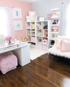 a pink and white girls'bedroom with shelving, desk, and bedding