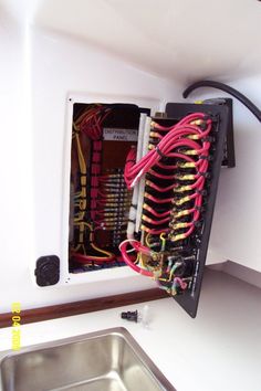 the inside of a boat with wires and other electrical equipment in it's compartment