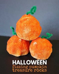 three oranges sitting on top of a black table next to each other with green stems