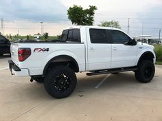 a white pick up truck parked in a parking lot