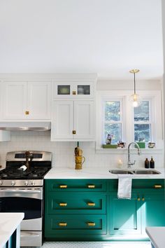 a kitchen with green cabinets and white counter tops in the center is an oven, sink, and stovetop