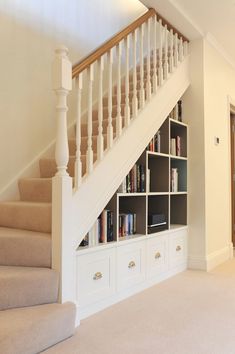 a staircase with bookshelves and drawers underneath the bannister in a home