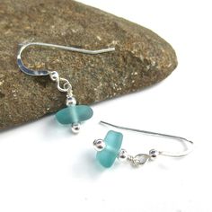 "*These earrings will be custom-made based on your selections. Please allow 2-3 business days for creation prior to shipping. The model is shown wearing the color aqua.* This sweet little pair of sea glass earrings feature two petite pieces of smooth sea glass in your choice of color. They are carefully drilled in the center and accented with shimmering sterling silver beads on either side for a touch of sparkle. They are shown here on sterling silver French hook ear wires. Use the drop-down men Beach Glass Necklace, Sea Turtle Necklace, Sea Glass Bracelet, Beach Necklaces, Sea Glass Earrings, Ocean Jewelry, Turtle Necklace, Color Aqua, Sea Glass Necklace