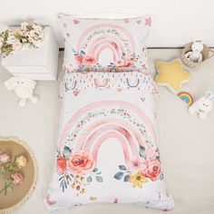 a white bed with pink flowers and rainbows on it