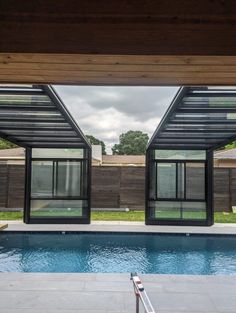 an outdoor swimming pool with glass doors leading to the patio and covered in wood planks