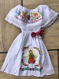 "Beautiful Mexican Virgen de Guadalupe embroidered dress for girls. Bow headband is included. Please note: Each piece is unique, the embroidery may be slightly different from the one pictured.. Dimensions: Size: 2T Chest- 24\" Length- 21\" Size: 4T Chest- 26\" Length-23\" Size: 6 Chest- 28\" Length- 24\" Size: 8 Chest- 30\" Length- 28\" Size: 10 Chest-32\" Length-32\" 🧺Care Instructions: Machine washable, lay flat to dry. 📲Please feel free to message me with any questions regarding sizing and White Floral Embroidered Baptism Dress, White Floral Embroidery Baptism Dress, Embroidered Fitted Baptism Dress For Summer, Fitted Embroidered Baptism Dress For Summer, Summer Embroidered Fitted Baptism Dress, Summer Baptism Dress With Embroidery, Summer Baptism Dress Embroidered, White Embroidered Baptism Dress For Summer, Summer Embroidered Baptism Dress