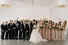 a large group of people standing next to each other in front of a white wall