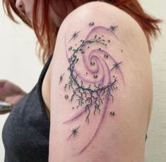 a woman with a tattoo on her arm has stars and swirls in the background