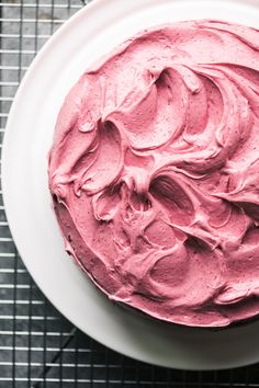 a close up of a cake on a plate with pink frosting in the middle