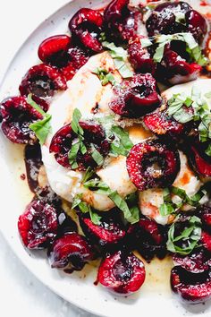 a white plate topped with meat covered in cherries