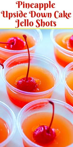 small plastic cups filled with orange jello shots and topped with a cherry garnish