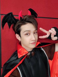 a young man with horns and devil wings on his head is posing for the camera