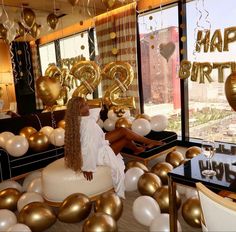 a woman sitting on top of a couch surrounded by balloons