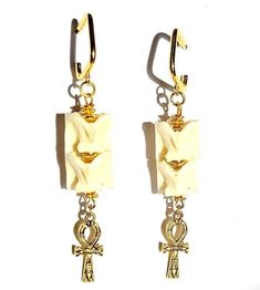 These Cobra snake earrings are not poisonous but they do leave a devastatingly fatal effect on their wearer!  Be forewarned! lol.  Decked out with Golden adornments and dangling Ankh charms, these earrings are meant to symbolize the "breath of life" ( nh = ankh ) in ancient Egyptian as well as protection as symbolized by the Cobra snake bones. The pairing of the Cobra snake bones are intentional, as ancient Egyptians held the Cobra in high esteem and considered it as a symbol of protection as evidenced in their wide use of the Cobras images prominently displayed in art, furniture, clothing, tombstones & of course, jewelry. The Genuine Cobra snake vertebrae bones measure about 1/2 an inch across and are of high quality. Antiqued gold plated Ankh charms measure 1 inch long. Earrings are fini The Cobra Snake, Snake Bones, Snake Vertebrae, Breath Of Life, Cobra Snake, Ancient Egyptians, Animal Bones, Snake Earrings, Antique Earrings