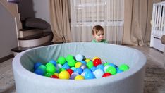 a little boy playing in a ball pit