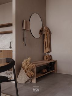 a room with a table, mirror and coat rack on the wall next to it