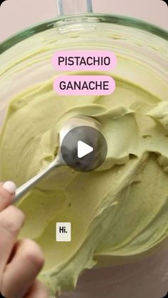 a person is mixing some food in a glass bowl with a spoon and the words pistachio ganache above it