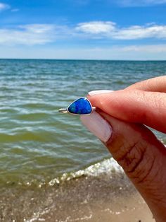 This gorgeous Australian Opal shimmers in medium to light blue, just like the ocean. It is bezel set in sterling silver and handmade in Western NY. Ocean-inspired Blue Ring For Gifts, Ocean-inspired Blue Ring For Gift, Ocean-inspired Blue Rings As Gifts, Adjustable Blue Opal Ring, Adjustable Blue Opal Gemstone Ring, Blue Opal Stackable Ring For Promise, Handmade Blue Opal Rings, Blue Stackable Opal Ring For Promise, Handmade Blue Opal Promise Ring