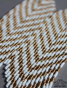 white and gold beaded fabric on grey surface