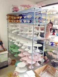 a woman standing in front of shelves filled with plates