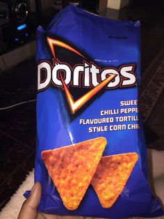 a hand holding a bag of doritos chips