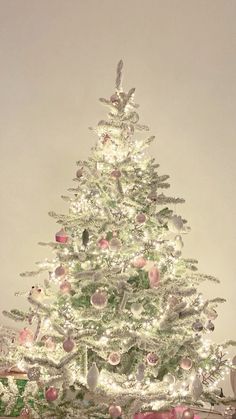 a white christmas tree with pink and silver ornaments